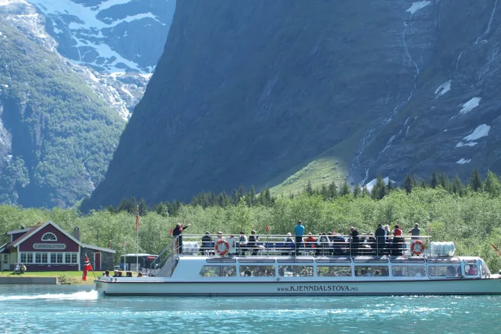 a boat in the water with a mountain in the background