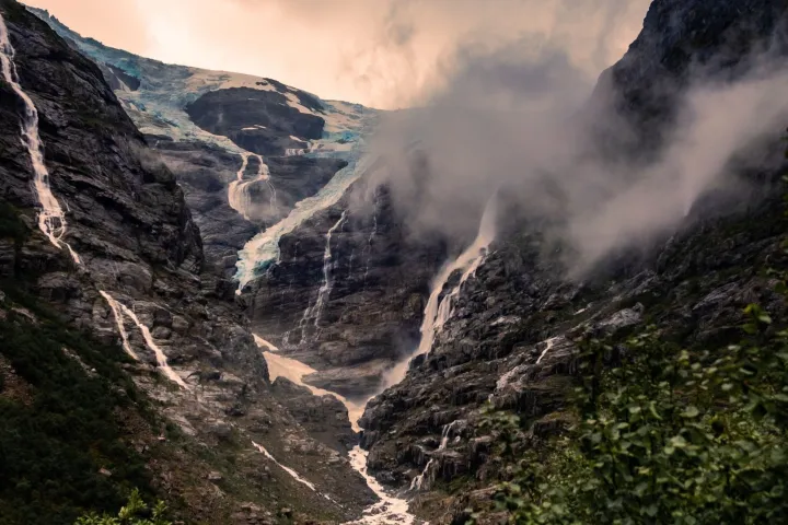 a rocky mountain with trees in the background