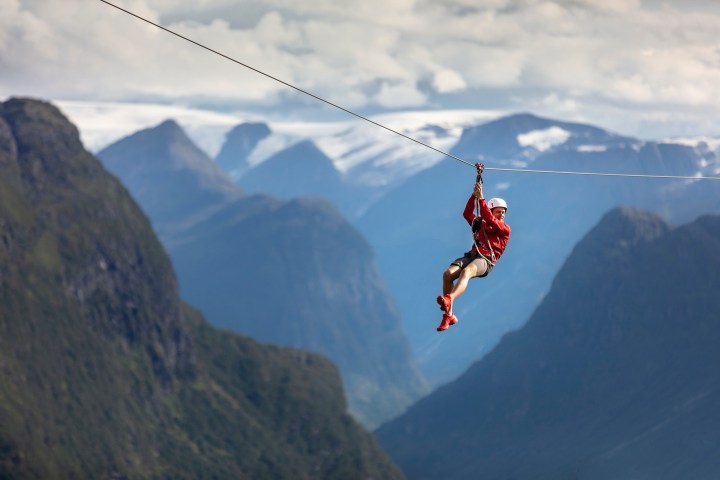 a man flying through the air on top of a mountain
