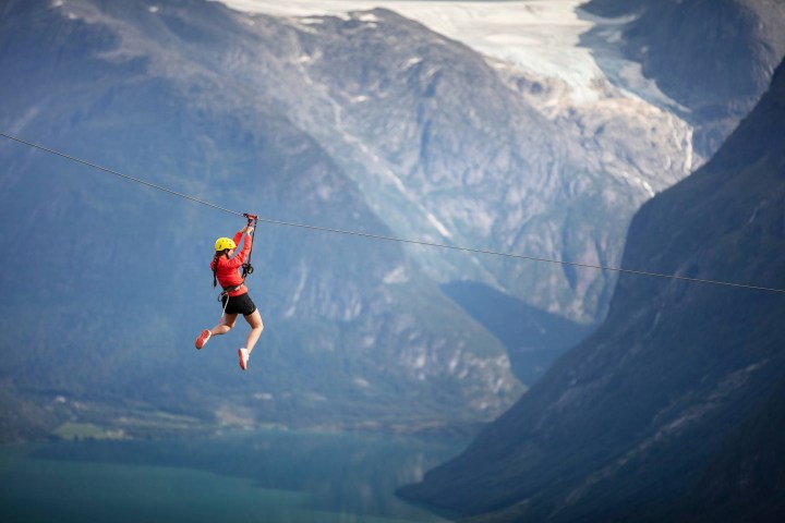 a man flying through the air on top of a mountain